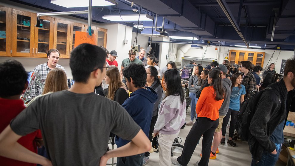 Many people fill the work space in Keck 308 during student presentations of the robotic systems they built for ME/CS/EE 134.