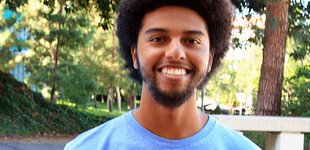 Graduate student Evan Nuñez stands, wearing a blue shirt