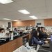 Several people at lab benches look across their equipment toward the front of the room.