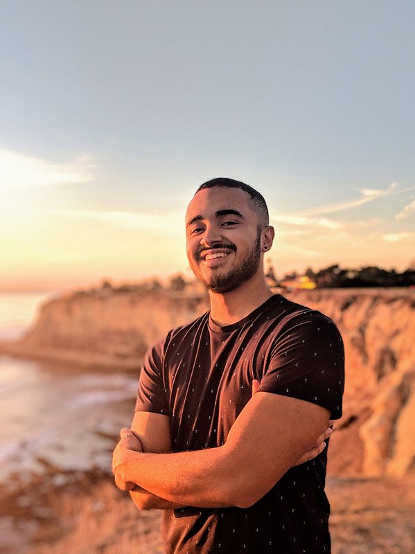Graduate student Sergio Parra stands with his arms crossed over his chest.