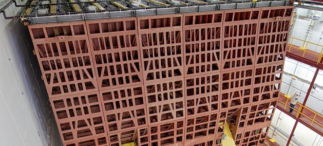 A massive neutrino detector that looks a like a red steel lattice the size of a building.