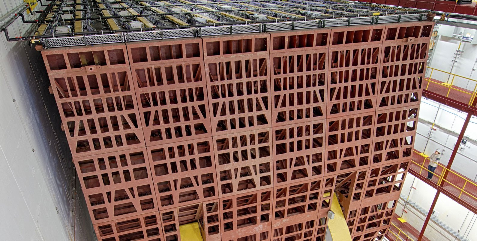 A massive neutrino detector that looks a like a red steel lattice the size of a building.