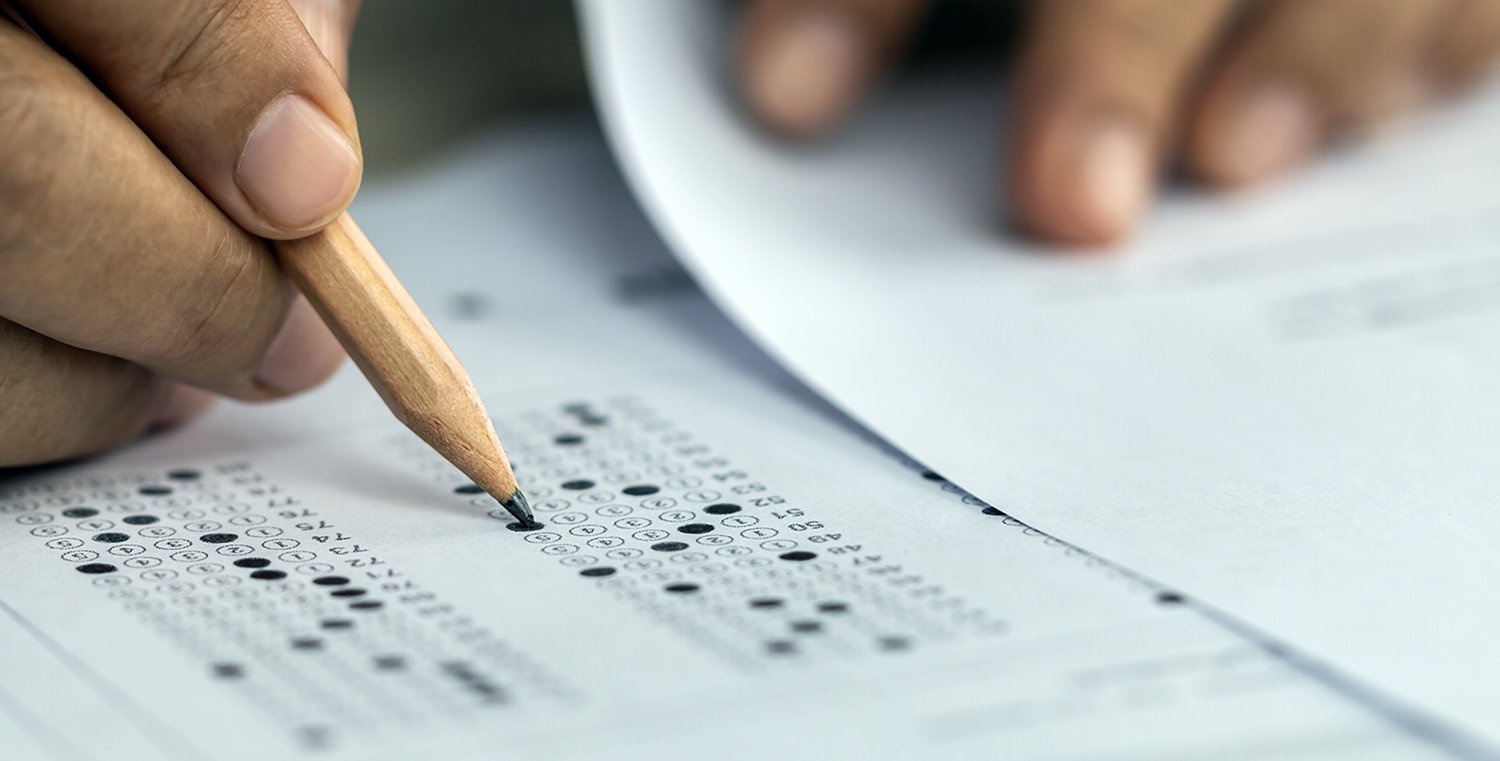 Hand with pencil fills in scantron bubbles