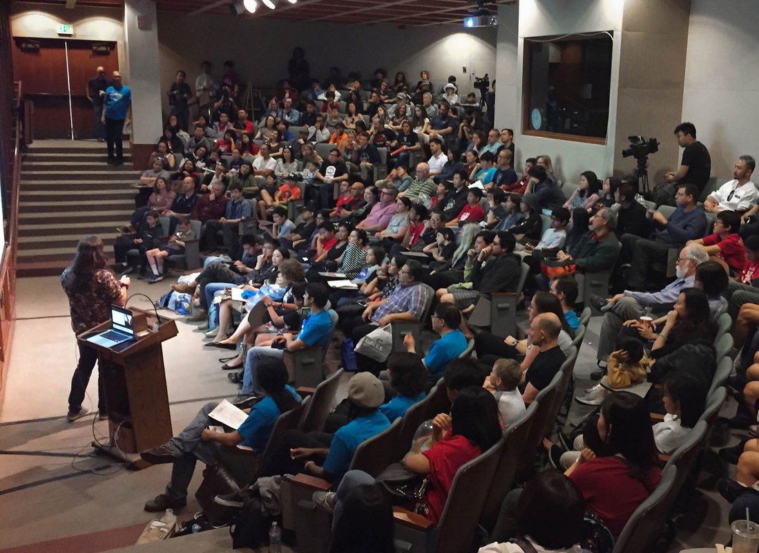 Audience members watch as a Science for March volunteer delivers a talk inside Beckman Institute Auditorium.
