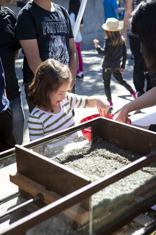 A 6-year-old child, Vivian Nunan, dips her finger in a bowl as part of an interactive science demonstration at Science for March.