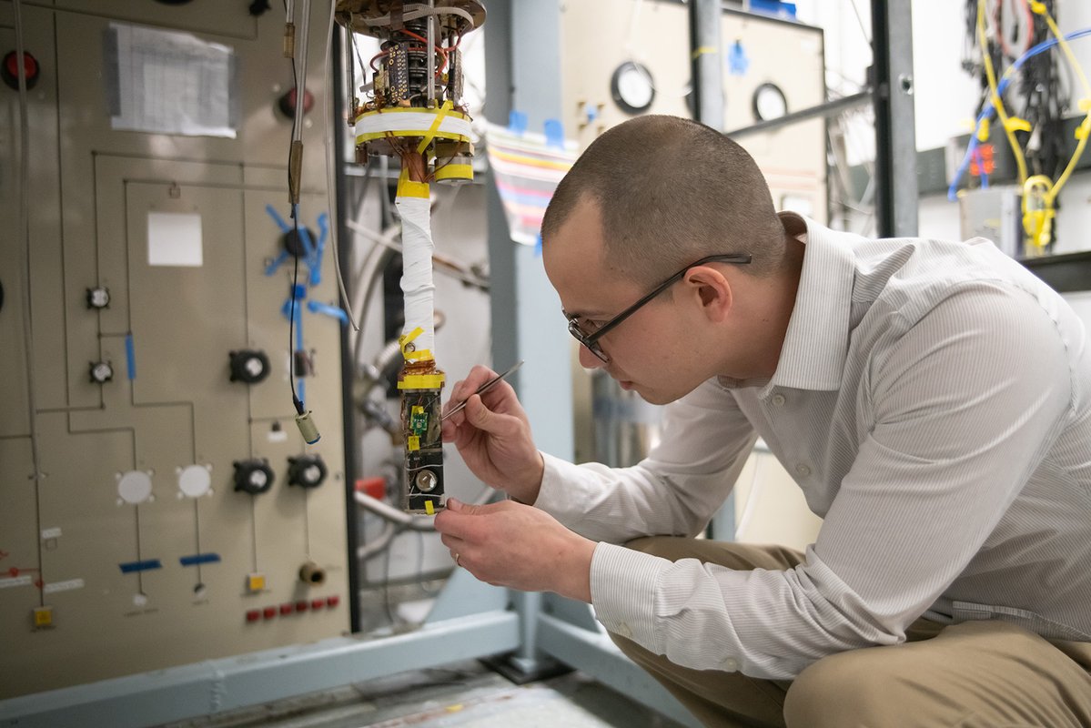Christopher Simon is pictured in the lab working on an apparatus to make magnetic measurements at cryogenic temperatures.