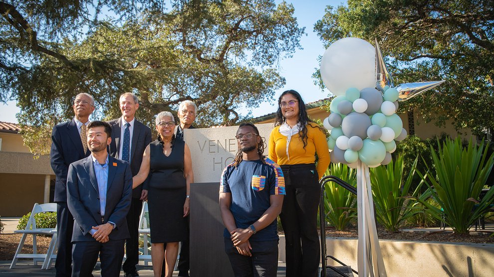 The event speakers posed around the Venerable House sign.
