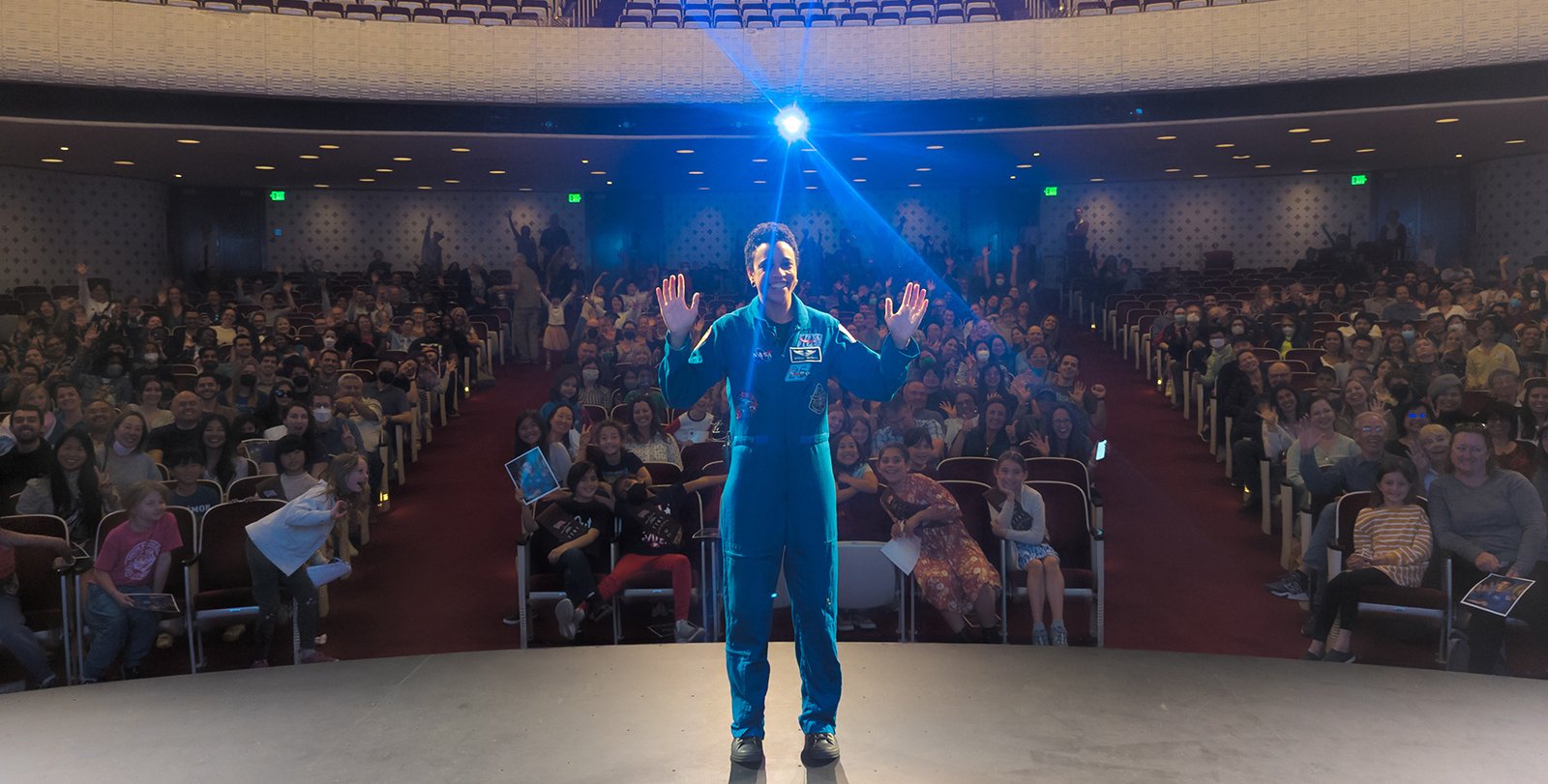 Jessica Watkins poses for a photo with the crowd in Beckman Auditorium