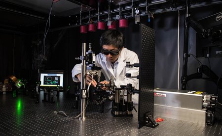 Jiamiao Yang, a postdoctoral scholar in the Caltech Optical Imaging Laboratory, adjusts a photoacoustic microscope.