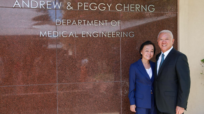 Photo of Peggy and Andrew Cherng, who endowed the Cherng Department of Medical Engineering in 2017, standing in front of its building.