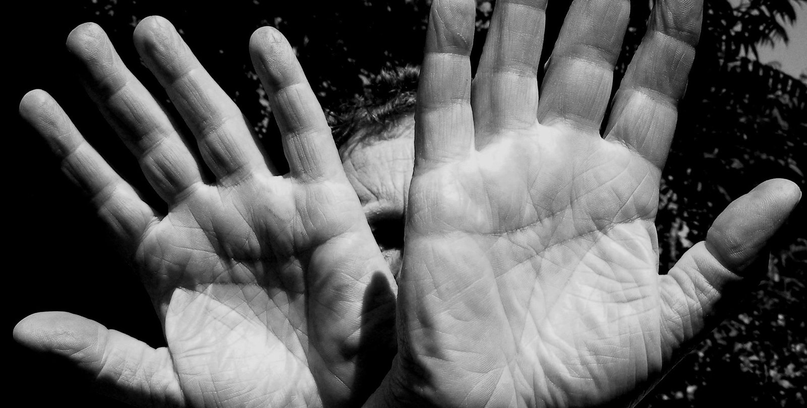 A black and white photo of two hands, palms facing the camera