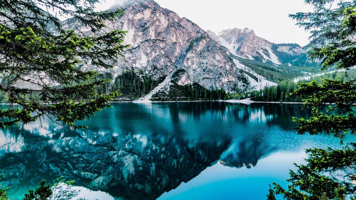 A lake reflects snowy mountains