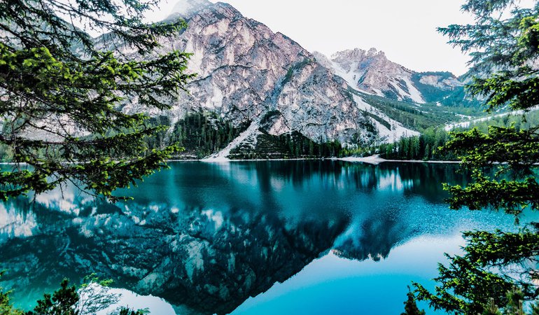A lake reflects snowy mountains
